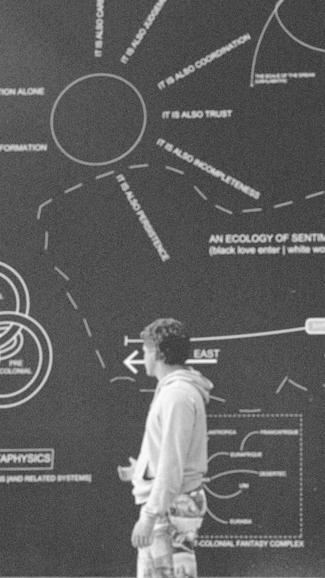 David Schlachter standing before a wall of diagrams