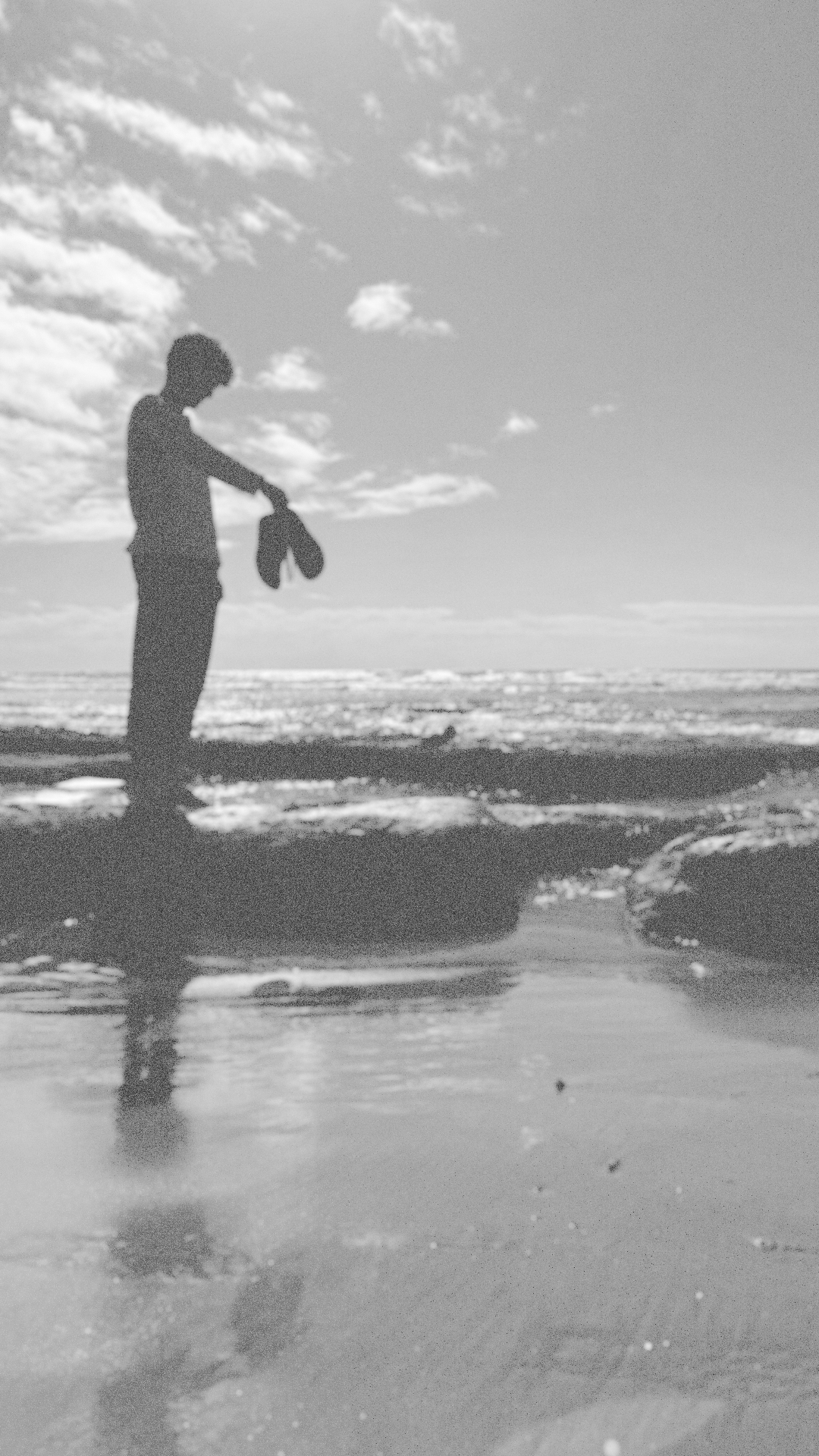 Larsen Schlachter standing at the edge of the ocean